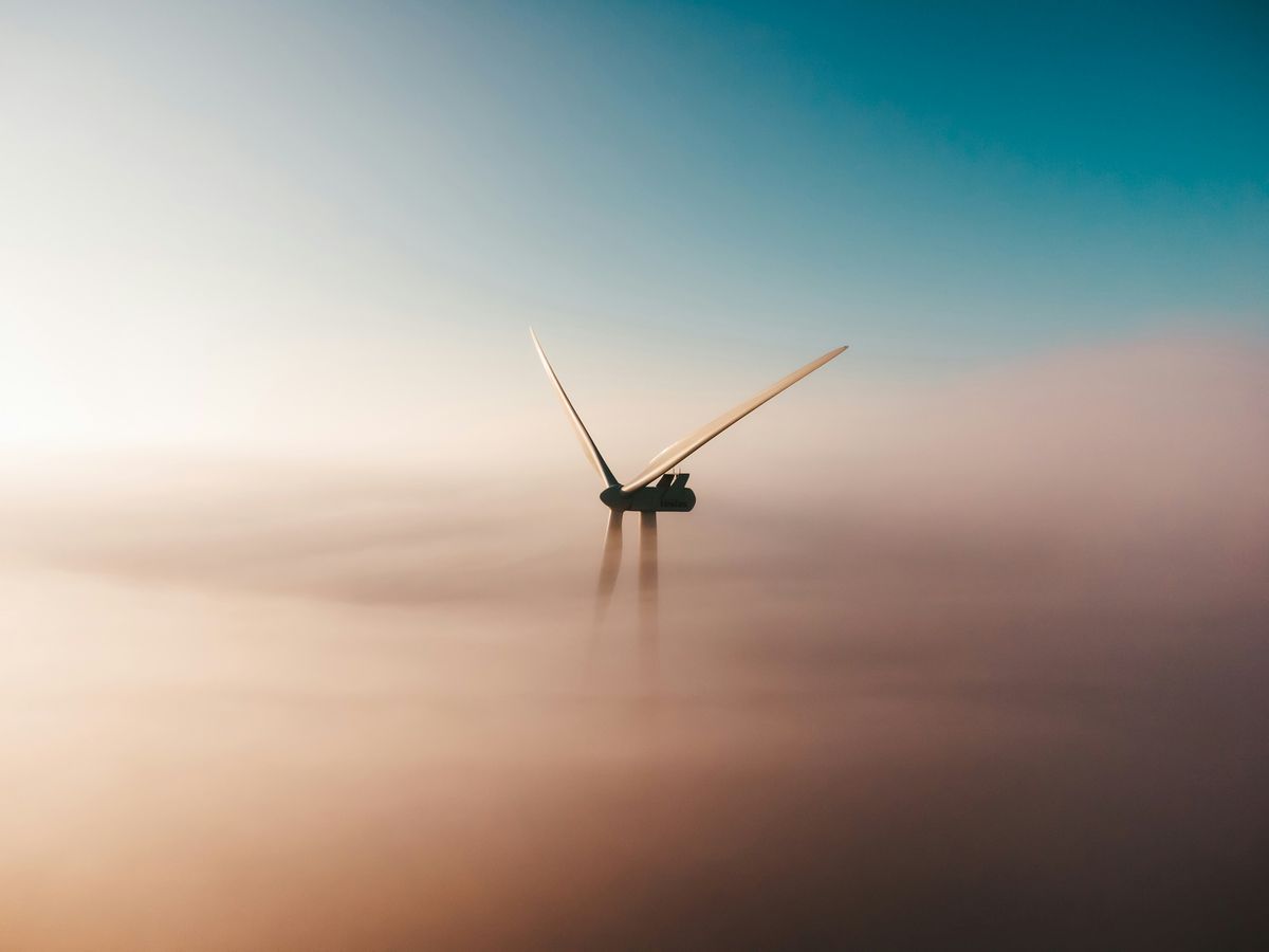 A wind turbine emerging from low cloud